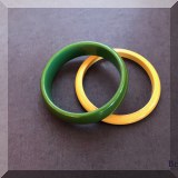 J142. 2 Bakelite bangles in different widths. One yellow and one green.  